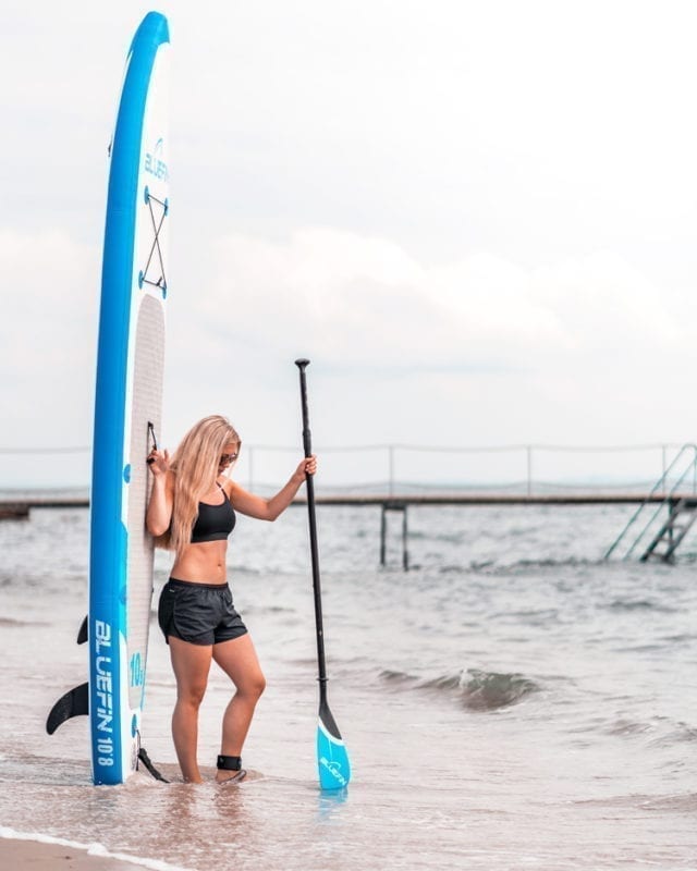 girl next to bluefin SUPs paddleboarding